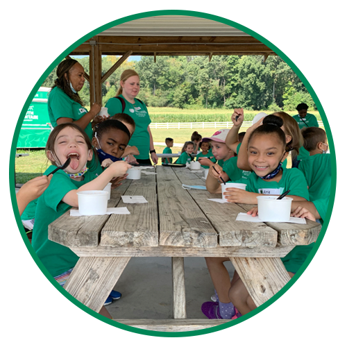 Group of young children and their teachers enjoying SMC ice cream at the farm pavillion