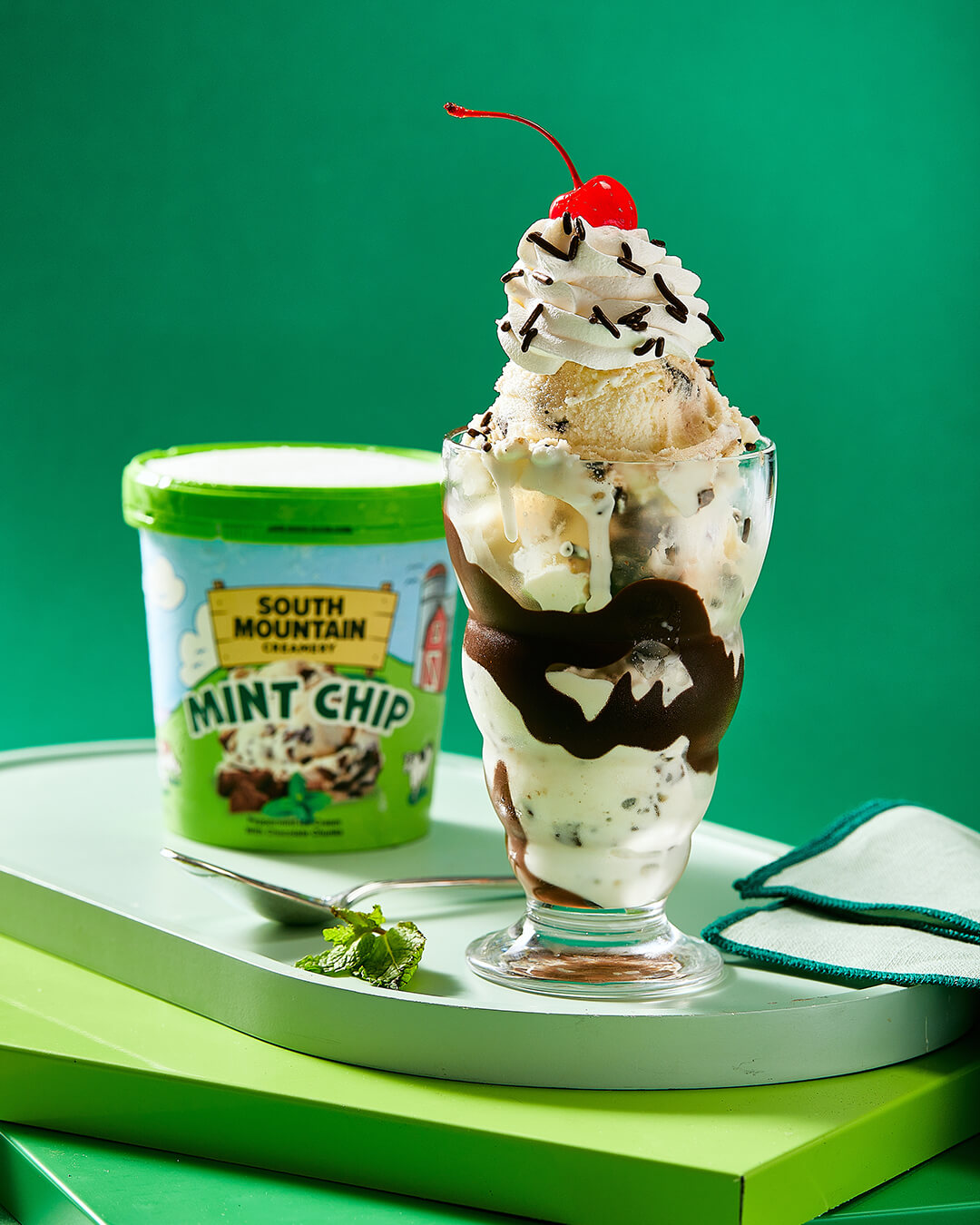SMC-Website-Re-Skin-how-ice-cream-is-made-7-25 SMC Butter Pecan Ice Cream in waffle cup next to spoon on a dark background