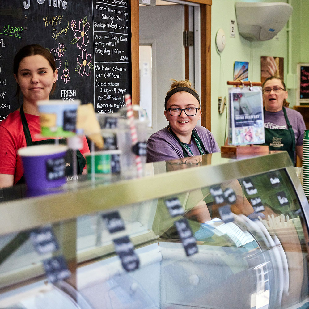 SMC-Website-Re-Skin-quote-7-25 smiling employees behind the ice cream counter